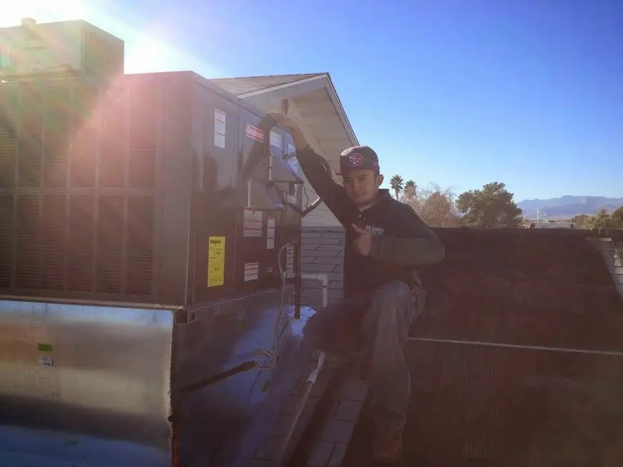 HVAC technician performing HVAC Inspection on a rooftop unit in Polson